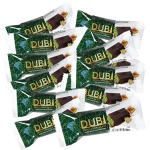 Dubai chokladbitar - Små chokladbitar inslagna i gröna och vita förpackningar med texten 'Dubai'. Chokladen ser ut att ha ett lager av mörk choklad och en fyllning inuti. Perfekt för dig som gillar sötsaker med lyxig känsla.