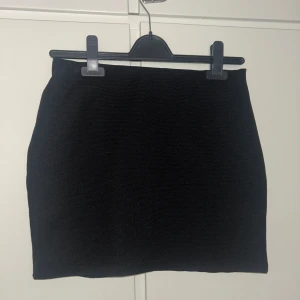 Svart minikjol från Zara - Säljer en svart minikjol från Zara. Kjolen har en enkel och stilren design med tight passform och är perfekt att matcha med olika toppar. Superenkel att styla för en trendig look.