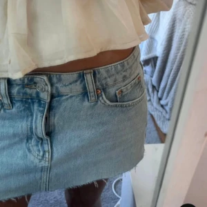 Lågmidjad Ljusblå jeanskjol från Gina Tricot - Säljer en jättesnygg ljusblå jeanskjol från Gina Tricot med fransig nederkant. Den är tyvärr för stor för mig och har inga defekter. Den är lågmidjad