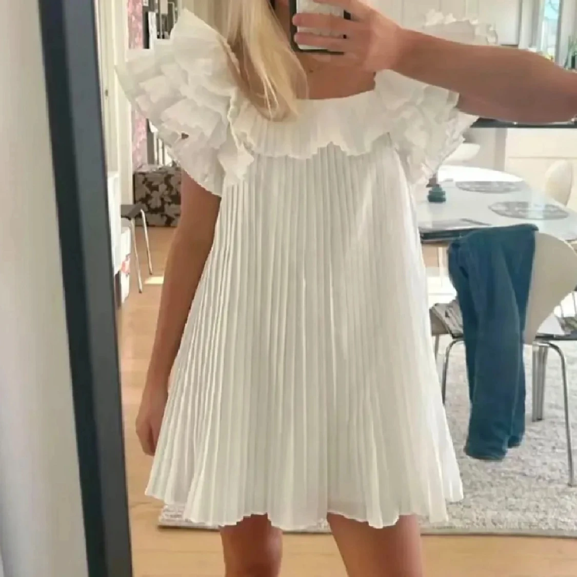 Vit plisserad klänning med volang