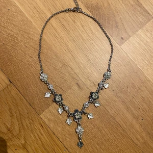 Halsband med blommor - Säljer ett super fint silvrigt halsband med blommor och blad motiv, det är i jätte bra skick men passar inte min stil längre.