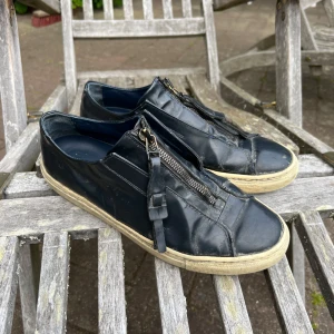 Mörkblå  sneakers från Filippa K med dragkedja - Mörkblå sneakers i skinn från Filippa K med  dragkedja framtill istället för klassisk snörning. Pris kan diskuteras
