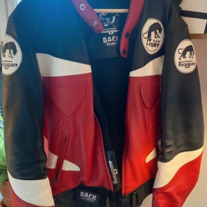 Röd och svart skinnjacka från Furygan - Säljer en riktigt fet skinnjacka från Furygan i rött, svart och vitt. Jackan har coola detaljer med broderad panter på ryggen, vadderade partier och dragkedjor framtill. skriv vid frågor eller funderingar ! 😊