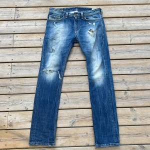 Diesel Thavar  - Säljer ett par blå Diesel Thavar jeans med slim skinny passform. Jeansen har slitna detaljer, hål och snyggt tvättad look. Klassisk femficksmodell med dragkedja och gylf. Storlek 30/32, 