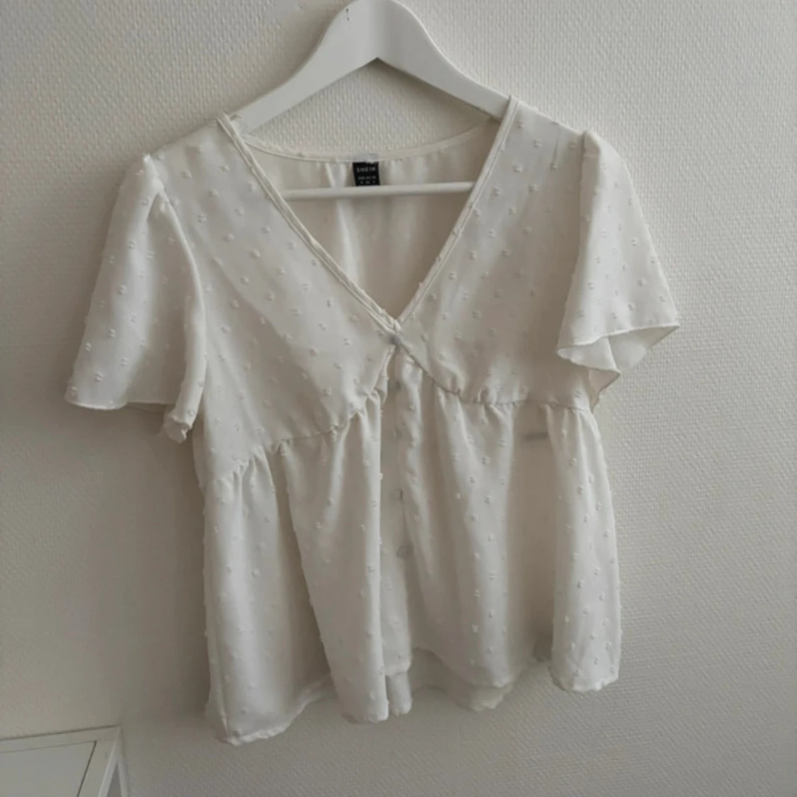 Vit blus med v-ringning och kort ärm