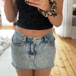 Blå jeanskjol från NA-KD, strl 36 - Säljer en snygg ljusblå jeanskjol från NA-KD i klassisk femficksmodell. Kjolen är kort, har rå kant nertill. 