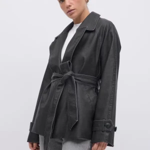 Svart skinn trenchcoat med bälte - Snygg svart trenchcoat i skinnimitation med bälte i midjan och stora slag. Från ginatricot, använd en gång! Storlek 38/M .