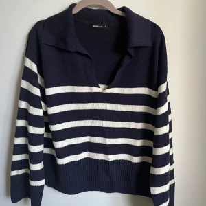 Stickad tröja från Gina Tricot - Mörkblå och vit randig stickad tröja från Gina Tricot med V-ringning. Andvänd några få gånger och går inte att köpa längre🩷😊