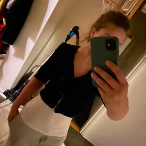 Svart stickad kofta från Kappahl - Säljer en svart stickad kofta från Kappahl med v-ringning och trekvartsärmar. Koftan har ett snyggt hålmönster och knäpps med tre knappar framtill. Perfekt att slänga över en topp för en chill och stilren look.