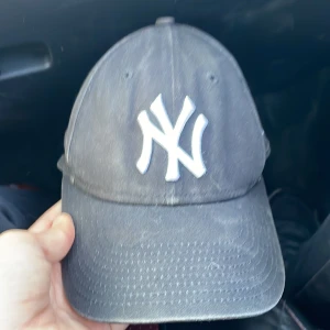 Svart New Era Yankees keps 9FORTY - Svart New Era 9FORTY keps med klassiskt New York Yankees broderat vitt logotyp framtill. Justerbar passform och böjd skärm. Kepsen är tillverkad i bomull och har New Era-logga broderad på sidan.