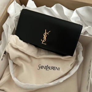 Saint Laurent cassandre leather - helt oanvänd och äkta, säljs pågrund av utgånget returdatum. digitalt kvitto från ysl och ordernummer finns, bara att höra av sig                      YSL CASSANDRE PHONE HOLDER IN SMOOTH LEATHER