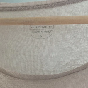 Beige långärmad topp Intimissimi S - Supermjuk och tunn beige långärmad topp från Intimissimi i Supima-bomull. Enkel och stilren design med rund halsringning, perfekt att styla lager på lager eller som den är. Sitter snyggt och känns riktigt skön mot huden.