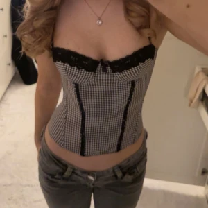 Korsett med spetsdetaljer - Säljer denna superfina rutiga korsetten med svarta spetsdetaljer, köp direkt för 599kr💗☺️