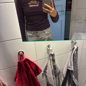 Randig långärmad Levi's tröja - Långärmad, randig tröja från Levi's i marinblått och vinrött. Är som ett mellanting mellan t-shirt och hoodie, så perfekt både om det är varmt och kallt!
