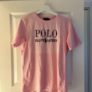 Rosa t-shirt från Polo Ralph Lauren - Snygg rosa t-shirt från Polo Ralph Lauren med svart broderad logga framtill. I princip helt ny. Storlek M, men passar även S. 