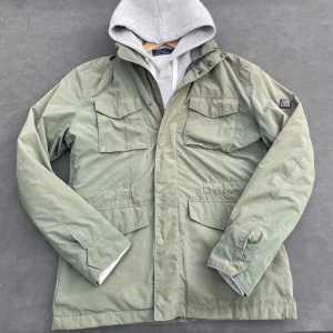J. Lindberg Field Jacket/Overshirt Olivgrön - Mycket bra skick och knappt använd. Inga skador eller defekter. Perfekt jacka nu till hösten. Nypris ligger omkring 3000kr. Hör av er vid frågor eller funderingar!!