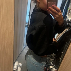 Svart bomberjacka från Zara - Säljer en svart bomberjacka från Zara med ribbade muddar och silverfärgade knappar framtill. Jackan är croppad och har en klassisk bomberkrage samt två fickor. Dessvärre har det blivit lite nopprigt under armen på jacken men det är inget som synd! 