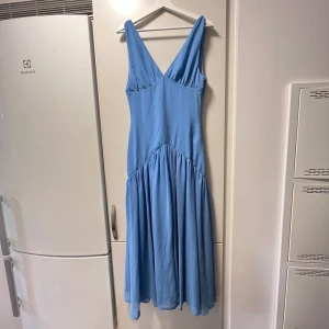Adoore klänning - Supersnygg blå långklänning från Adoore. Storlek 38, men passar mig som har 36/38. Helt ny med lapp kvar! Klänningen har ett flowigt fall med rynkad kjol och dragkedja i sidan. Perfekt för  fest/bal/bröllop! Det är en av Adoores Sample därav pris❤️skriv privat för mer frågor