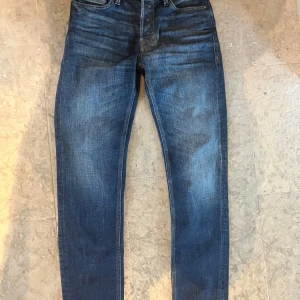 Jack and Jones Jeans  - Aldrig använda Jack and Jones jeans. Modellen är slim fit med raka ben och normal midja. Jeansen är gjorda i bomull och har detaljerade sömmar samt metallnitar vid fickorna. Perfekt för dig som gillar stilrena och tidlösa jeans. Nypris: 1000