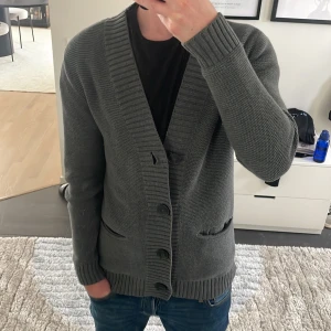 Grå stickad cardigan grå HM - Säljer en fet grå stickad cardigan från HM. Passar peruker nu för lite kallare väder. Modellen är ca 180. Hör av dig vid funderingar 