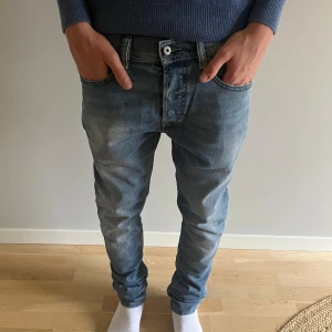 Diesel jeans slimfit - Säljer ett par klassiska blå jeans från Diesel i storlek 30 slim fit. Jeansen har en snygg tvättad look och slim passform. Fickor fram och bak, samt Diesel-logga på myntfickan. Perfekta till sneakers och hoodie.