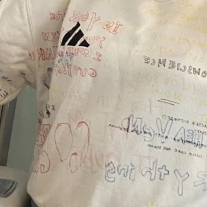 Vit adidas yeezy tröja Season 5 med graffiti-tryck - Unik tröja från Season 5 i storlek S, täckt med graffiti-inspirerade texter och teckningar i rött, blått, svart och gult. Adidas-logga på bröstet. Tröjan har rund hals, tillverkad i mjuk bomull. Perfekt för dig som gillar streetstyle och statement-plagg. Fler foto finns om så önskas 