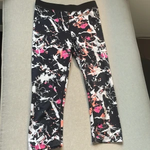 Färgstarka leggings från H&M - Snygga leggings från H&M med ett coolt abstrakt mönster i svart, vitt, orange och rosa. De är stretchiga och sitter tight, perfekta för dig som gillar att sticka ut. Materialet är polyester och elastan för maximal komfort. Dom går till ungefär nedanför knäna! 