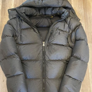Grå pufferjacka från Polo Ralph Lauren - Säljer en fet ralph lauren jacka t vintern. Nästan inte använd, fett bra skick. Om ni vill fråga npt är de bara att fråga på. Skriv om ni vill se passformen me. Man kan förhandla me priset vid snabb affär.🤙🤙