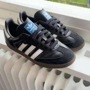 Adidas Samba OG svarta - Supersnygga adidas samba i storlek 38, använda under en sommar och vår men bra skick. Litet märke på utsidan se bild 3. Har fixat iordning skorna genom att rengöra hela skon ink. innersulor och snören, samt putsat upp dom. Pris kan diskuteras.