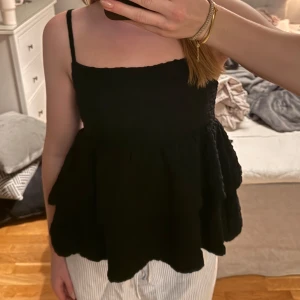 Svart volang topp från Gina Tricot - Säljer en svart volang topp från Gina Tricot i stolek S. Toppen sitter tight över bysten och har två volanger. Axelbanden går att ändra efter behov. Den är i mycket bra skick. Hör gärna av dig vid frågor💗