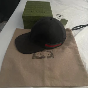 Gucci Canvas keps I svart - Hej! Jag säljer min Gucci canvas keps i svart, storlek S. Den är mycket sparsamt använd men har tydliga tecken på att den är använd. (Blev solblekt denna sommaren när jag var i Spanien med min flickvän). Ny pris: 5650kr. Kepsen är 100% äkta. Fick den som present av min flickvän. 