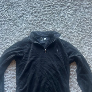 Svart half zip tröja Polo Ralph Lauren - På bild 2 ser ni att de fläckar där som är bruna de går inte bort men de ja gjorde va att ta en svart tuschpenna å måla över så syns de knappt man kan även få me den om det önskas.Svart långärmad tröja från Polo Ralph Lauren med klassisk half zip-dragkedja och broderad logga på bröstet. Tillverkad i mjuk bomull, perfekt för lager-på-lager och chill stil. Snygg och enkel att matcha med det mesta. 