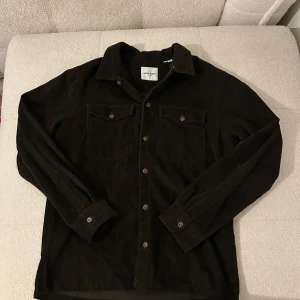 Mörkgrön manchesterskjorta Jack & Jones - Säljer en mörkgrön manchesterskjorta från Jack & Jones i storlek M. Skjortan har klassisk krage, två bröstfickor med knappar och långa ärmar. Perfekt för dig som gillar en stilren look nu till hösten🙌