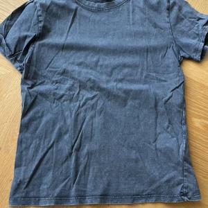 Mörkgrå ”jeans” t-shirt i bomull - En enkel och stilren mörkgrå t-shirt med rund hals och korta ärmar. Tillverkad i mjuk bomull som känns skön mot huden. Perfekt för dig som gillar en clean och avslappnad look. Passformen är normal och tyget har en lätt tvättad känsla. Använd få tal gånger❣️strl xxs men passar xs och S också