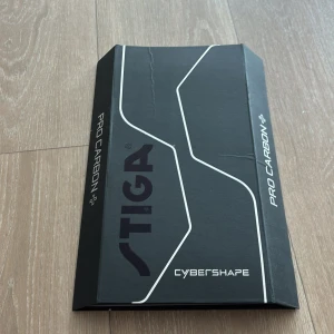 Pro Carbon Cybershape Pingis Rack  - Pro Carbon Cybershape från STIGA är ett exklusivt pingisracket i modern design, perfekt för dig som vill ta ditt spel till nästa nivå. Levereras i snygg förpackning och med skyddsfodral – redo för både träning och tävling. Passar unga och sportintresserade.