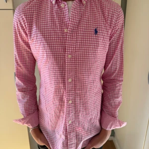 Rosa rutig skjorta från Ralph Lauren - Snygg rosa och vit rutig skjorta från Ralph Lauren. Skjortan passar storlek XS och är i perfekt skick. Skjortan är snygg och trendig. Bara höra av er vid minsta lilla fundering😇