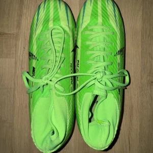 Nike Mercurial Fotbollsskor - Säljer ett par Nike Mercurial Dream Speed CR7 fotbollsskor i neon-grönt med svarta detaljer och snörning. Skorna har en högre strumpliknande krage och är designade för spel på konstgräs och gräs. Perfekta för dig som vill sticka ut på planen. Pris kan diskuteras vid smidig affär. Kvitto finns. 
