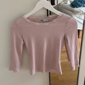 Ljusrosa topp med spets  - Supersöt ljusrosa ribbad topp från FB Sister med trekvartsärm och fin spetsdetalj runt halsen! Kontakta vid frågor eller funderingar💗