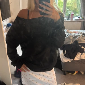 Svart offshoulder tröja - Svart oversized tröja som jag klippt till offshoulder som ger en chill och avslappnad vibe. Långa ärmar och lös siluett, perfekt att styla med kjol eller jeans. Enkel och stilren design utan synliga detaljer eller mönster.