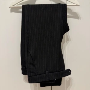 Randiga kostymbyxor från Les Deux - Snygga svarta kostymbyxor från Les Deux med tunna ränder. Byxorna har slim fit-passform. I mycket fint skick! 