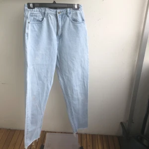 Ljusblå jeans - Säljer ett par ljusblå jeans med raka ben  , fransiga längst nere. Jeansen har klassisk femficksdesign och stängs med knapp och dragkedja. 
