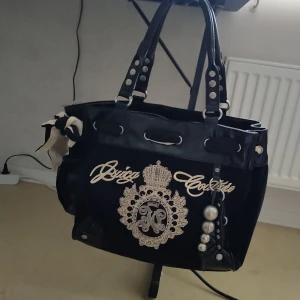 Äkta vintage Juicy Couture väska,svart  - Svart handväska från Juicy Couture i sammet och skinn med guldigt/silvrigt broderi, väska har små detaljer. VÄSKAN HAR ANVÄNDS MAX 3 GÅNGER.
