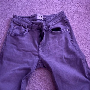 Grå bootcut jeans från 157 - Snygga grå jeans från 157 med bootcut-modell och låg midja. Klassisk femficksdesign och dragkedja. Perfekta för dig som gillar en avslappnad men trendig look. Materialet är mjukt och följsamt jeans.