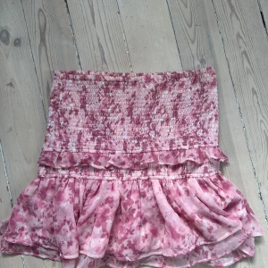 Rosa blommig volangkjol - Gullig kjol från Gina Tricot. Den har små tecken på användning, men man behöver tvätta den så är den som ny.