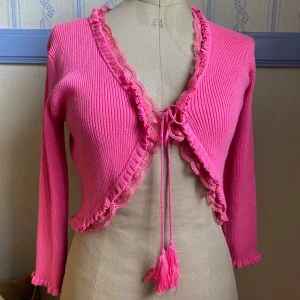 Rosa kofta från Soyaconcept - Supersöt rosa kofta från Soyaconcept med spets och knytband framtill. Croppad modell med långa ärmar och med jättefina detaljer🩷