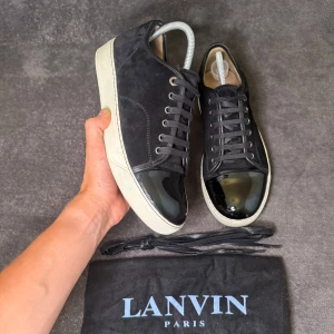 Svarta Lanvin DBB1 Cap Toe UK 7 - Säljer nu ett par riktigt fräscha, svarta Lanvin DBB1 Cap Toe | storlek UK 7 vilket motsvarar 40,5 men passar 41,5 | skick 9/10, endast använda 2 gånger, inga defekter, bara två mini mini repor på cap toe som knappt syns, du kan själv se på bilderna, och några ljus gula fläckar på undersidan av sulan som inte heller syns när man har på sig de | du får även med Lanvin dustbag och extra Lanvin skosnören | skriv vid frågor!