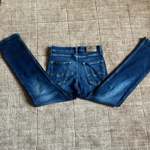 Blå Replay jeans straight fit - Snygga blå jeans från Replay med klassisk femficksdesign och raka ben. Jeansen har coola slitningar och tydliga kontrastsömmar, samt Replay-logga på fickan. Perfekta för dig som gillar en tidlös och avslappnad look. Designen ska vara slitet. Pris i butik ca 800 så en bra deal. Dem funkar också till nästan alla överdelar eftersom det är en bra lowkey färg!
