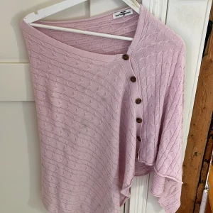 Ljusrosa kofta från Hampton Republic - Supersöt ljusrosa kofta från Hampton Republic med snyggt stickat mönster och bruna knappar framtill. Koftan har en avslappnad passform och är tillverkad i mjukt stickat material. Perfekt att slänga över en topp för en chill look. ( har några fläckar som säkert går bort i tvätten) :)