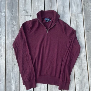 Vinröd merinoullströja från Riley - Snygg vinröd långärmad tröja från Riley i mjuk merinoull. Tröjan har en slimmad passform och har storleken M.