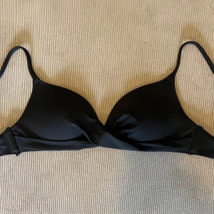 Svart bikiniöverdel från H&M - Stilren svart bikiniöverdel från H&M med vadderade kupor och smala, justerbara axelband. Helt slutsåld och storlek 34 men passar XS/S. Bra skick!! 👙🫧🧘🏼‍♀️
